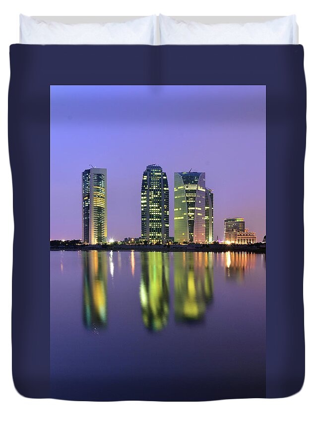 Tranquility Duvet Cover featuring the photograph 4 Skyscrapers Glow At Night Over The by Photography By Azrudin