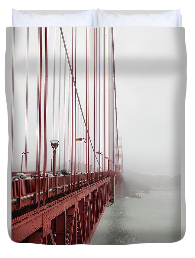 Sailboat Duvet Cover featuring the photograph A Small Sailboat Passes Under The by Ethan Welty