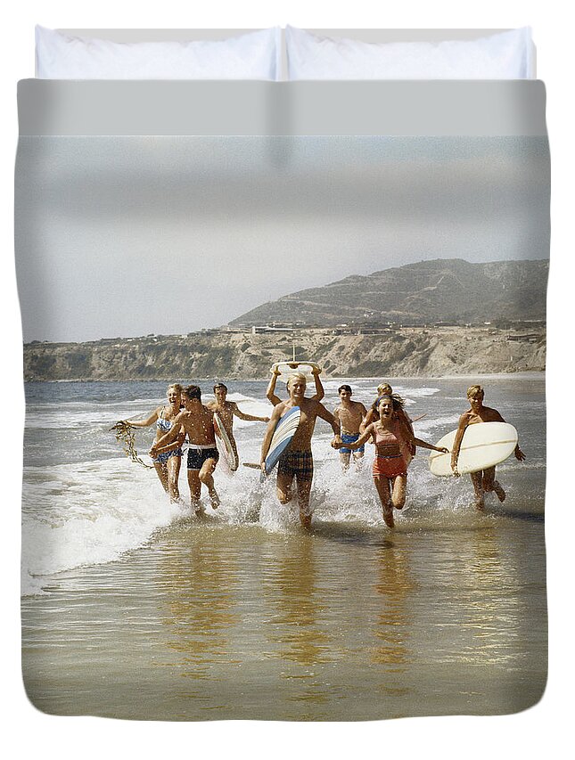 Young Men Duvet Cover featuring the photograph Group Of Surfers Running In Water With by Tom Kelley Archive