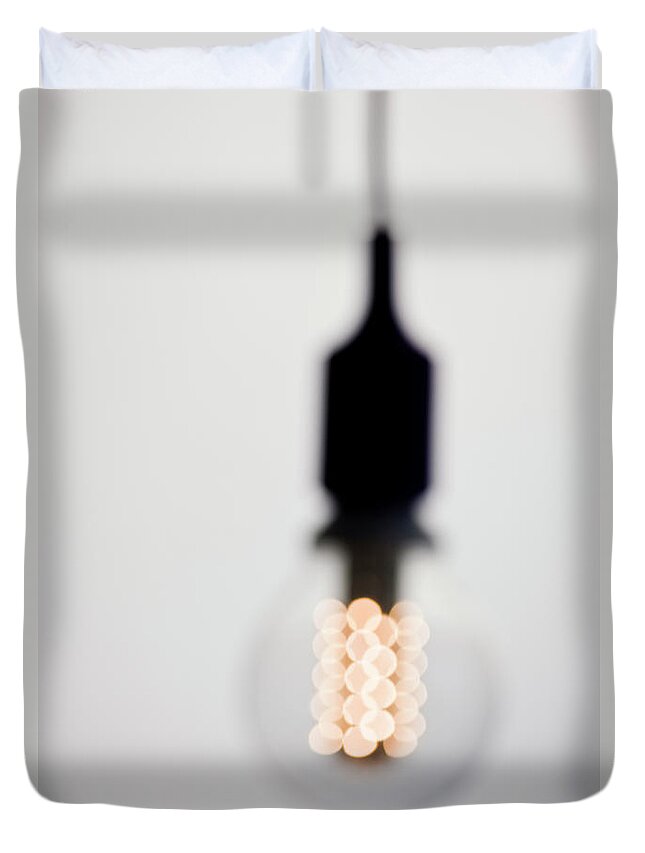 Environmental Conservation Duvet Cover featuring the photograph Illuminated Light Bulb, Defocused by Johner Images