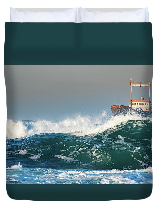 Shipwreck Duvet Cover featuring the photograph Abandoned ship in the stormy ocean by Michalakis Ppalis