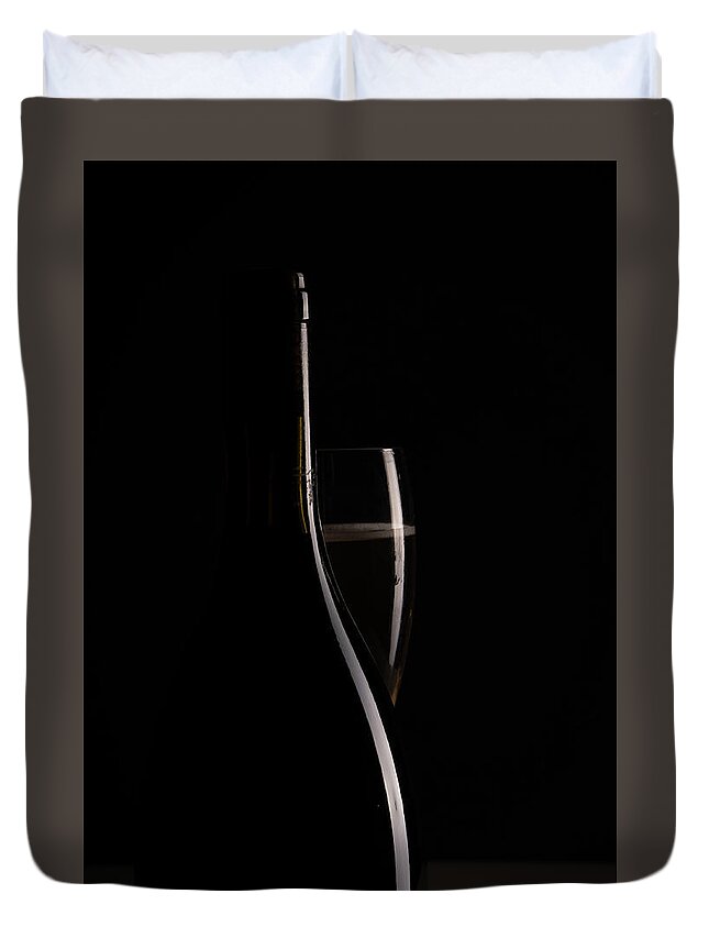 Red Wine Duvet Cover featuring the photograph Red sparking wine on a wineglass and black wine bottle. by Michalakis Ppalis