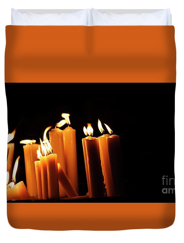 Candle Duvet Cover featuring the photograph Religious candles on black background. Yellow candlelight f by Jelena Jovanovic