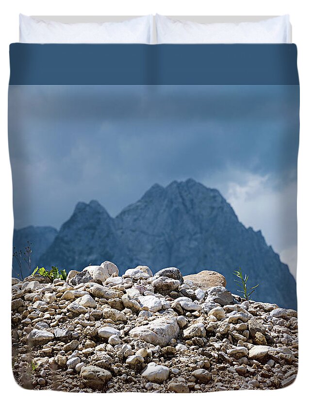 Mountains Duvet Cover featuring the photograph Stony hill with plants in front of a mountain range. by Bernhard Schaffer