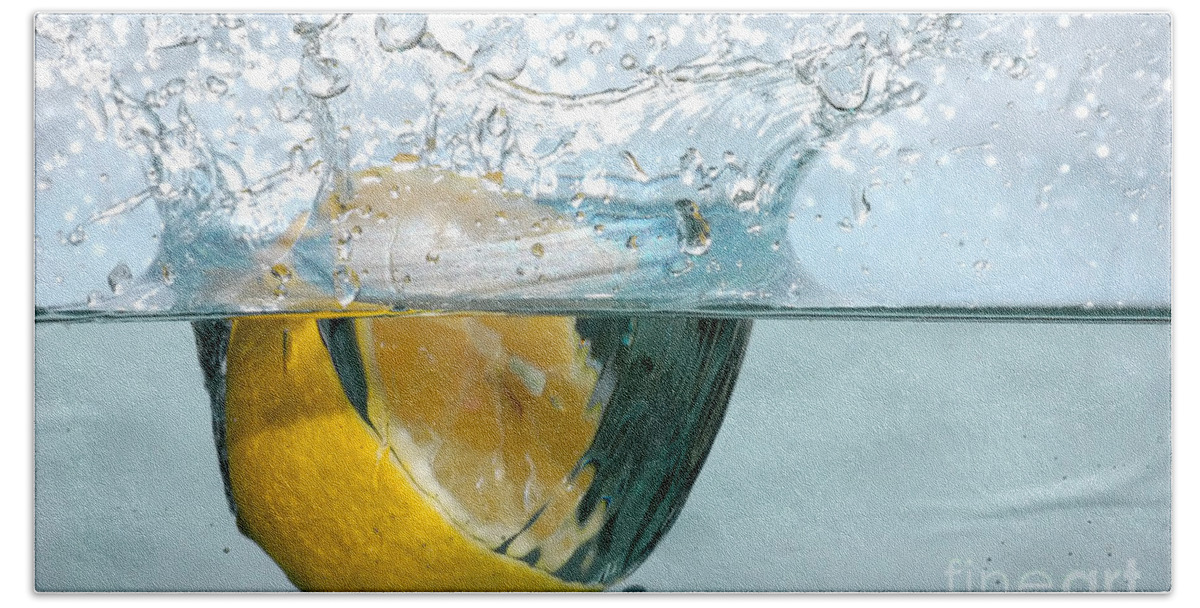 Aqua Bath Towel featuring the photograph Lemon splash into water #1 by Michal Bednarek