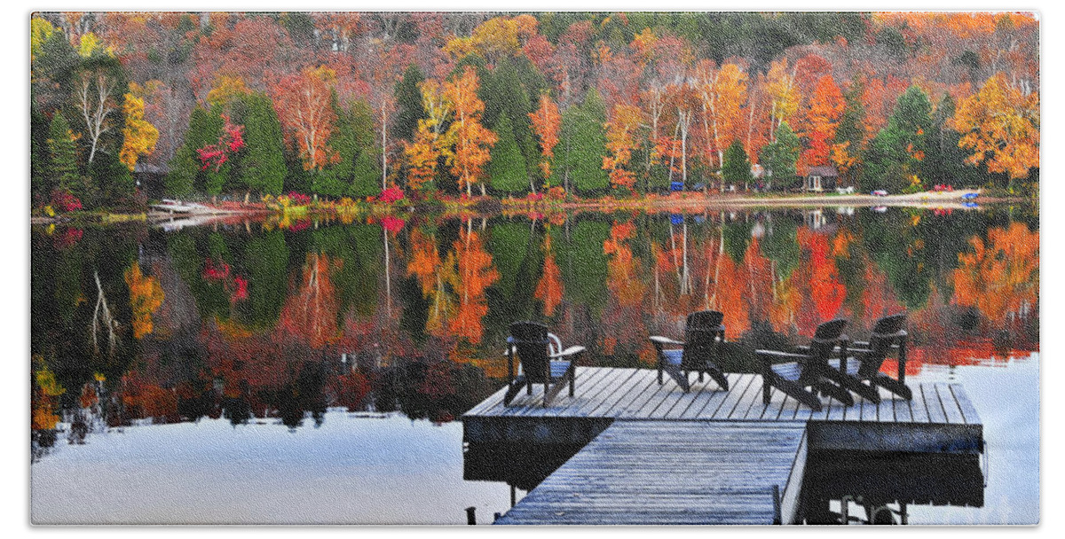 Lake Hand Towel featuring the photograph Wooden dock with chairs on autumn lake by Elena Elisseeva