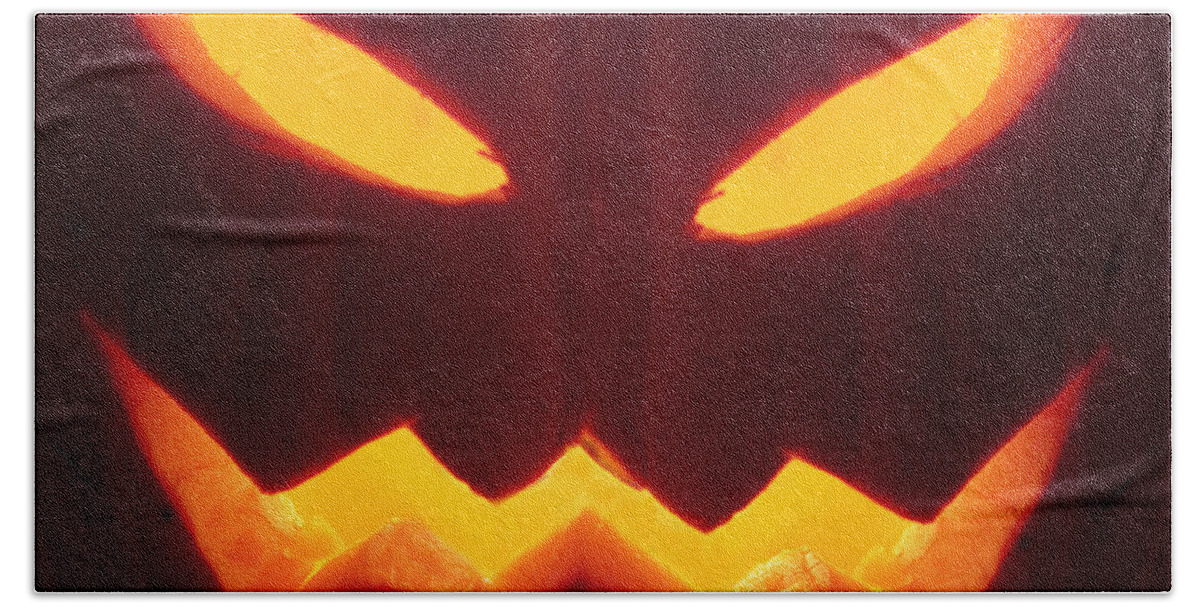 Pumpkin; Glow; Glowing; Dark; Darkness; Jack O Lantern; Horror; Haunting; Haunted; Haunt; Ghoul; Frightening; Moody; Scary; Fright; Eerie; Foreboding; Shadow; Night; Ominous; Evil Fear; Foreboding; Seasonal; Halloween; Carved; Close Up; Eyes; Mouth Hand Towel featuring the photograph Glowing Pumpkin by Margie Hurwich