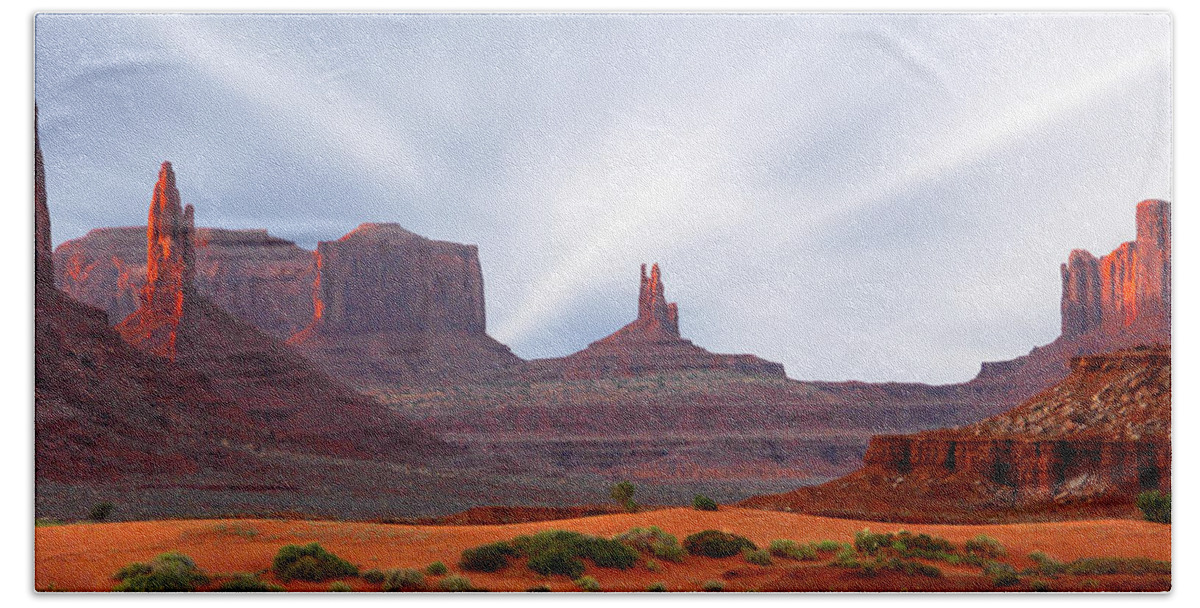 Desert Bath Towel featuring the photograph Monument Valley at Sunset Panoramic by Mike McGlothlen