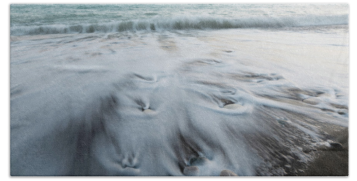Coastline Bath Towel featuring the photograph Pebbles in the beach and flowing sea water by Michalakis Ppalis