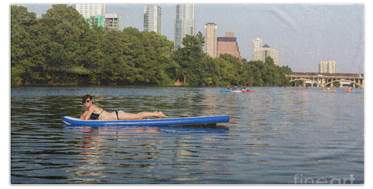 Sup Hand Towel featuring the photograph A woman having a great time sunning on a stand up paddle boarding, SUP on Lake Austin with the Austin Skyline in the background - Stock Image by Dan Herron