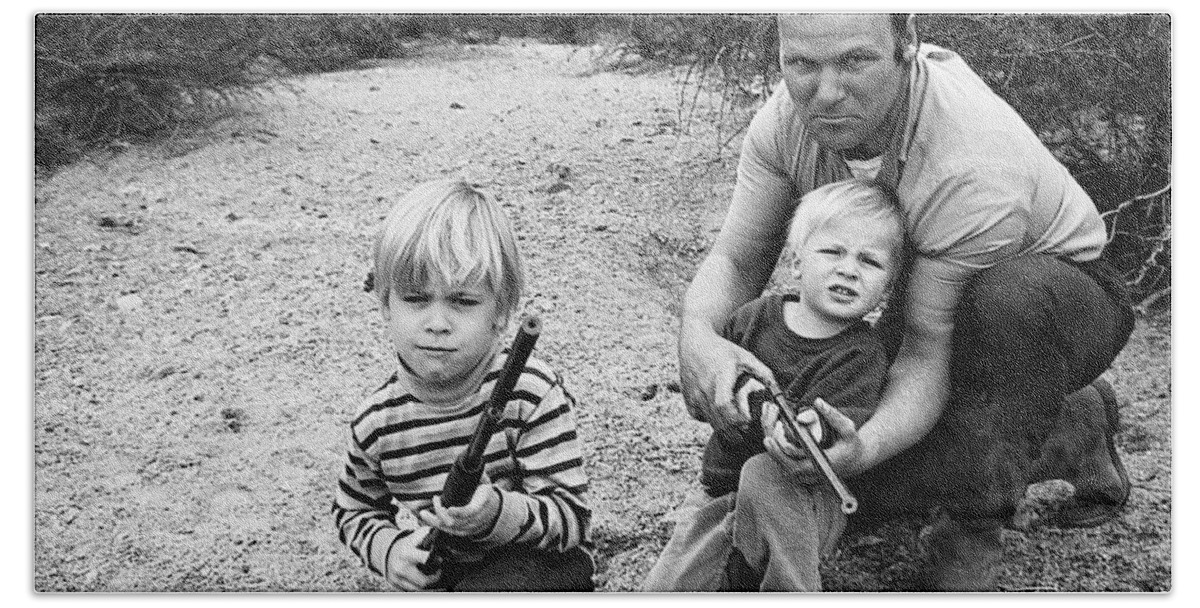 Barry Sadler Instructing Sons Shooting With Toy Rifles Tucson Arizona 1971 Bath Towel featuring the photograph Barry Sadler instructing sons shooting with toy rifles Tucson Arizona 1971 by David Lee Guss