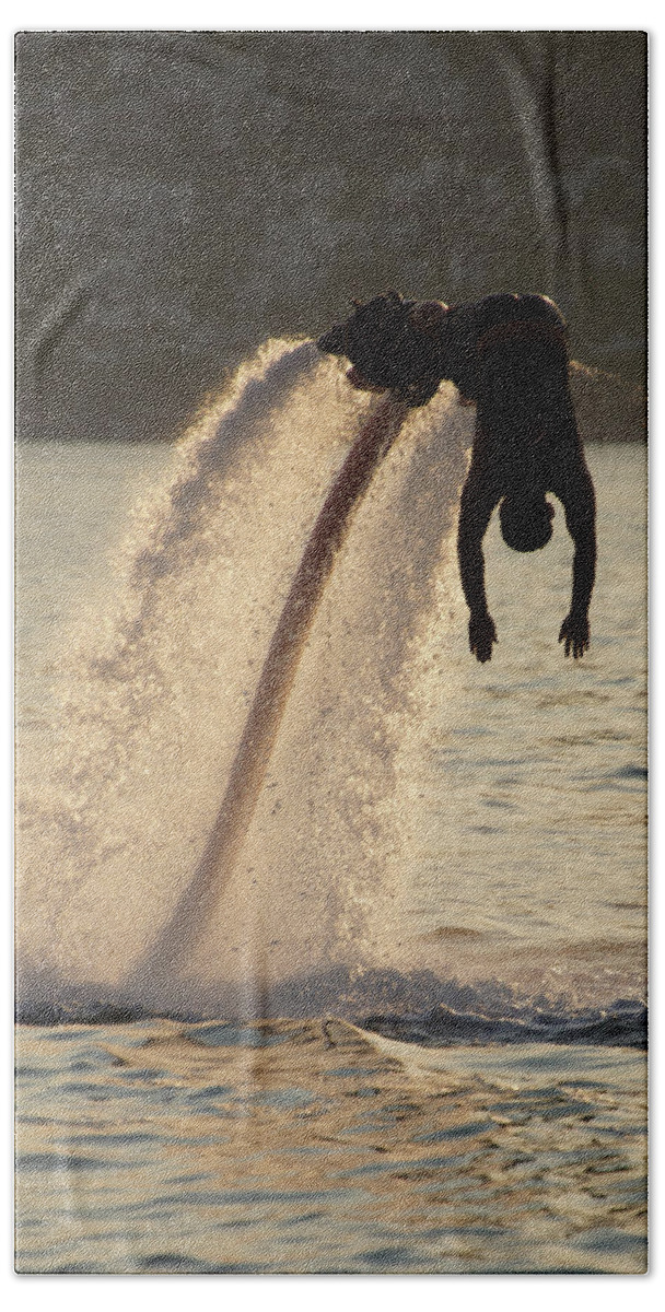 Bodrum Bath Towel featuring the photograph Flyboarder silhouetted in dive towards evening sea by Ndp