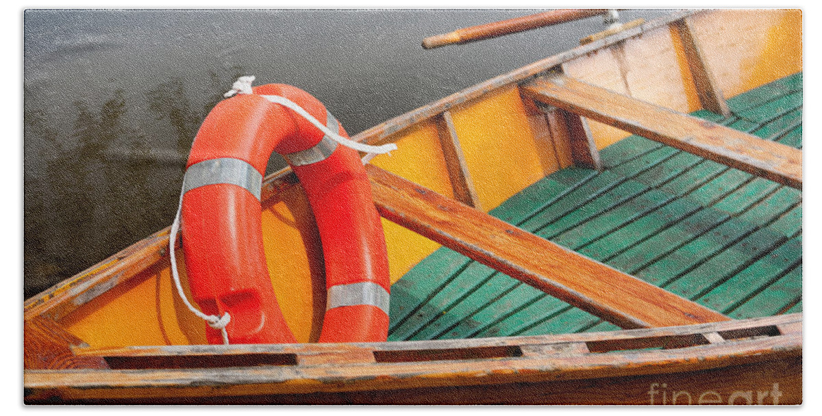 Attraction Hand Towel featuring the photograph Orange life belt in wooden boat by Arletta Cwalina