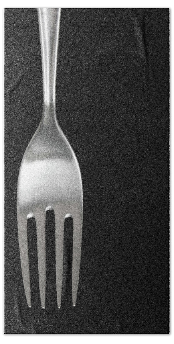 Fork Hand Towel featuring the photograph Shiny silver fork on black background by GoodMood Art