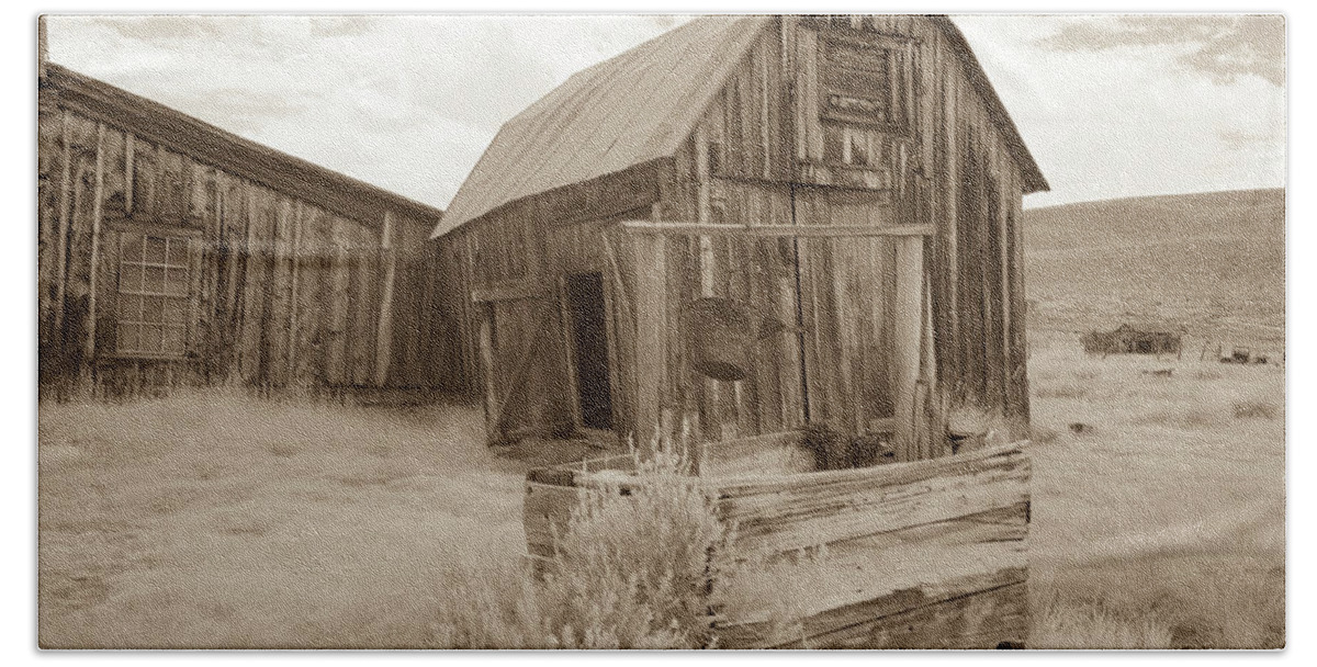 Abandoned Hand Towel featuring the photograph Well outside old barn in Bodie, California in sepia by Karen Foley
