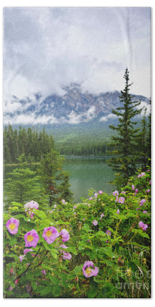 Wild Rose Bath Towel featuring the photograph Wild roses and mountain lake in Jasper National Park by Elena Elisseeva