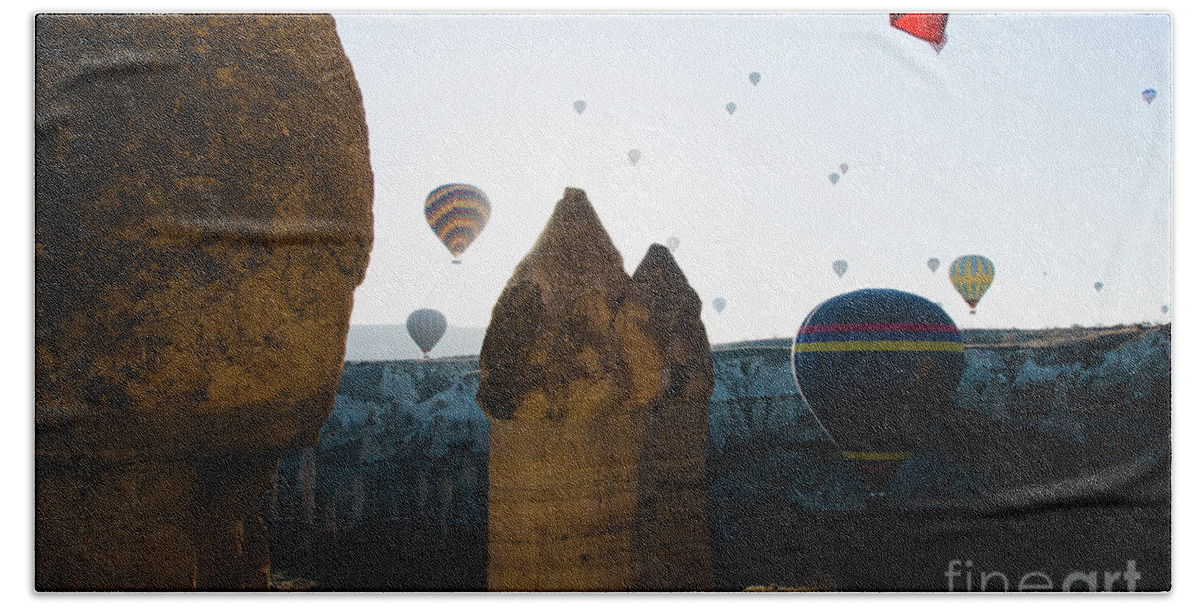 Adventure Hand Towel featuring the photograph hot air balloons for tourists flying over rock formations at sunrise in the valley of Cappadocia. #4 by Joaquin Corbalan