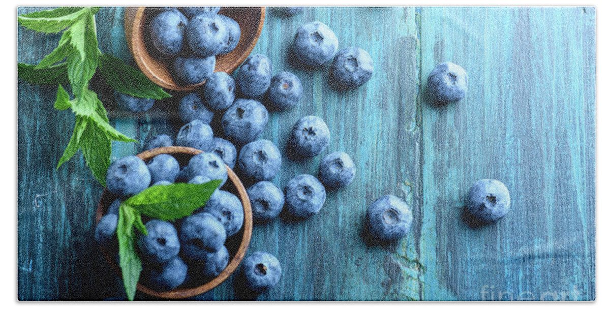 Blueberries Hand Towel featuring the photograph Bowl of fresh blueberries on blue rustic wooden table from above by Jelena Jovanovic