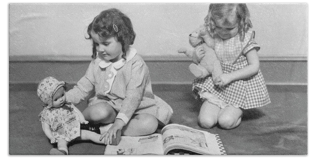 1930s Two Girls Sitting On Floor Playing One Girl Reading Book To Doll  Other Holding Teddy Bear Bath Towel