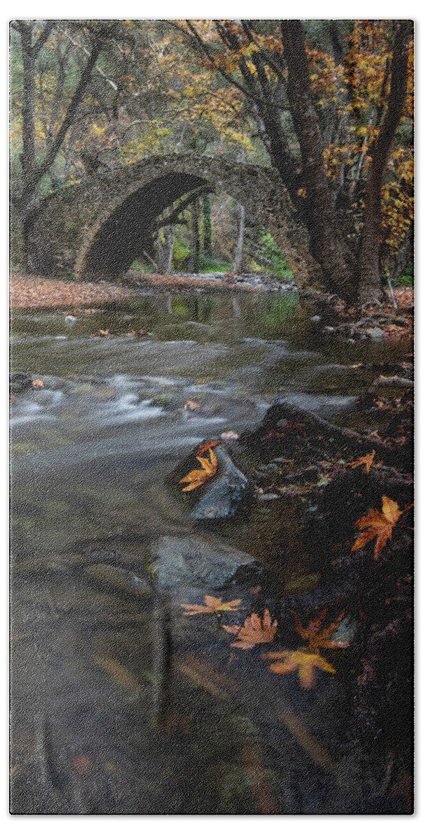 Autumn Bath Towel featuring the photograph Autumn landscape with river flowing under a stoned bridge by Michalakis Ppalis
