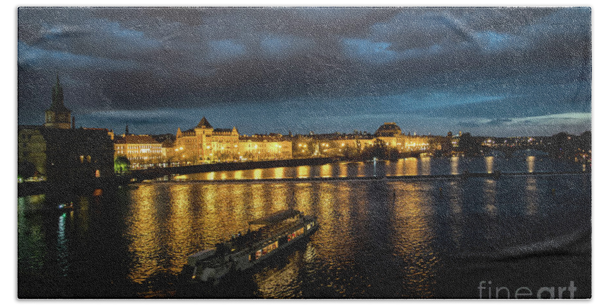 Architecture Bath Towel featuring the photograph Illuminated Moldova River With Ship And Buildings In The Night In Prague In The Czech Republic by Andreas Berthold