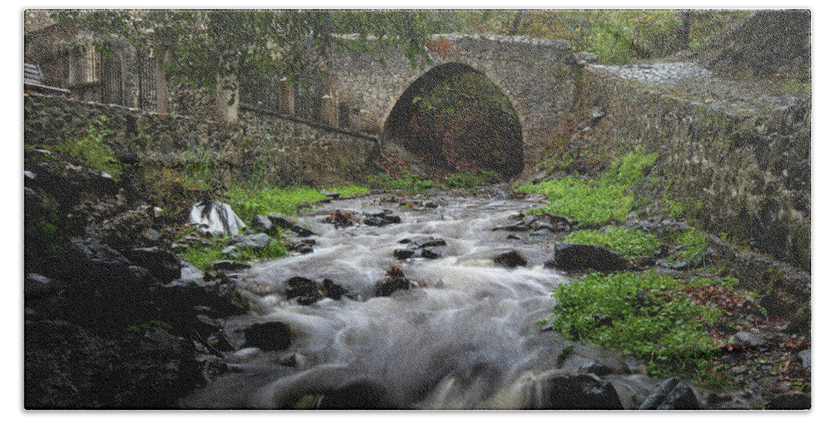 River Bath Towel featuring the photograph Medieval stoned bridge water flowing in the river. by Michalakis Ppalis