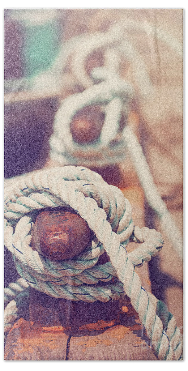 Sea Bath Towel featuring the photograph Quayside cleats and tied ropes with boats moored in the backgrou by Jane Rix