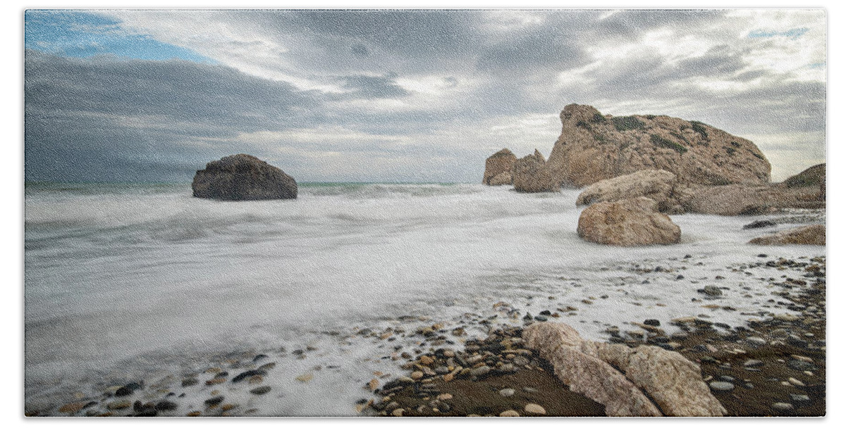 Seascape Bath Towel featuring the photograph Seascape with windy waves splashing at the rocky coastal area. by Michalakis Ppalis