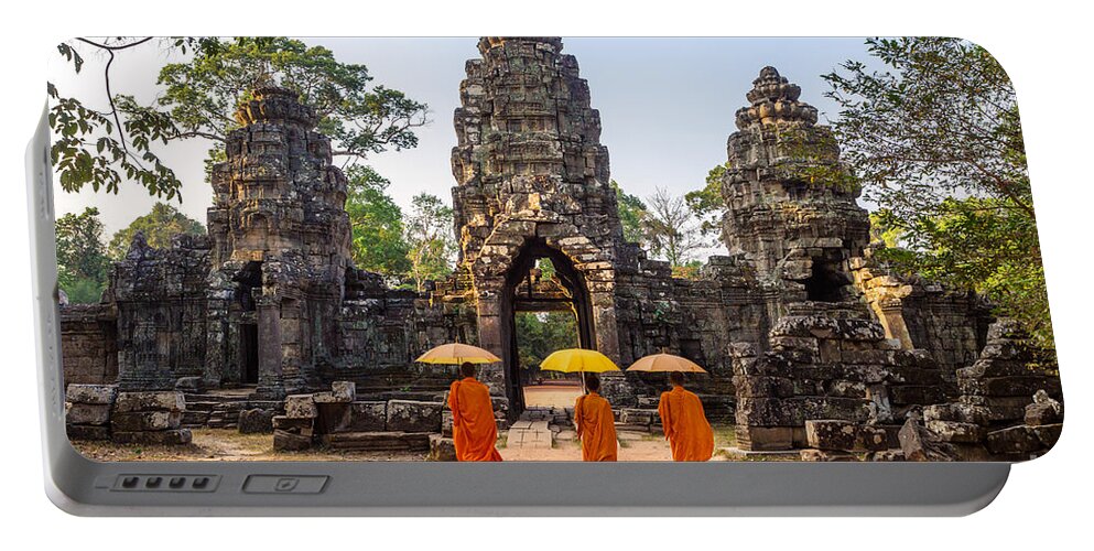 Angkor Portable Battery Charger featuring the photograph Monks with umbrella walking into Angkor Wat temple - Cambodia #1 by Matteo Colombo