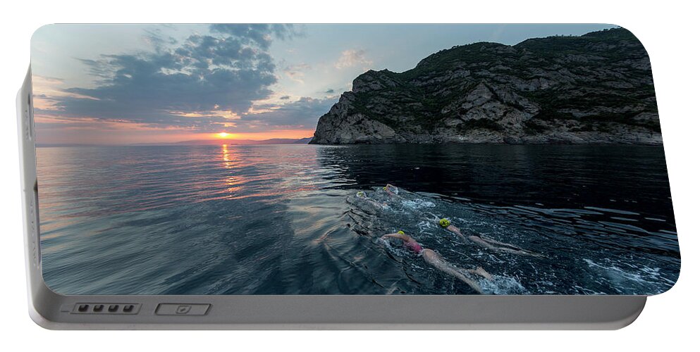 Horizon Over Water Portable Battery Charger featuring the photograph A Group Of Swimmers Swimming by Raffi Maghdessian