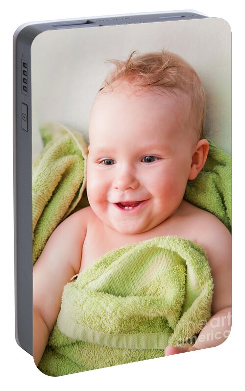 Baby Portable Battery Charger featuring the photograph A happy baby lying on bed in green towel by Michal Bednarek