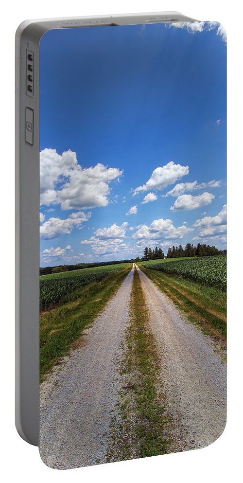 Sky Portable Battery Charger featuring the photograph A Long Rural Road by Bill and Linda Tiepelman