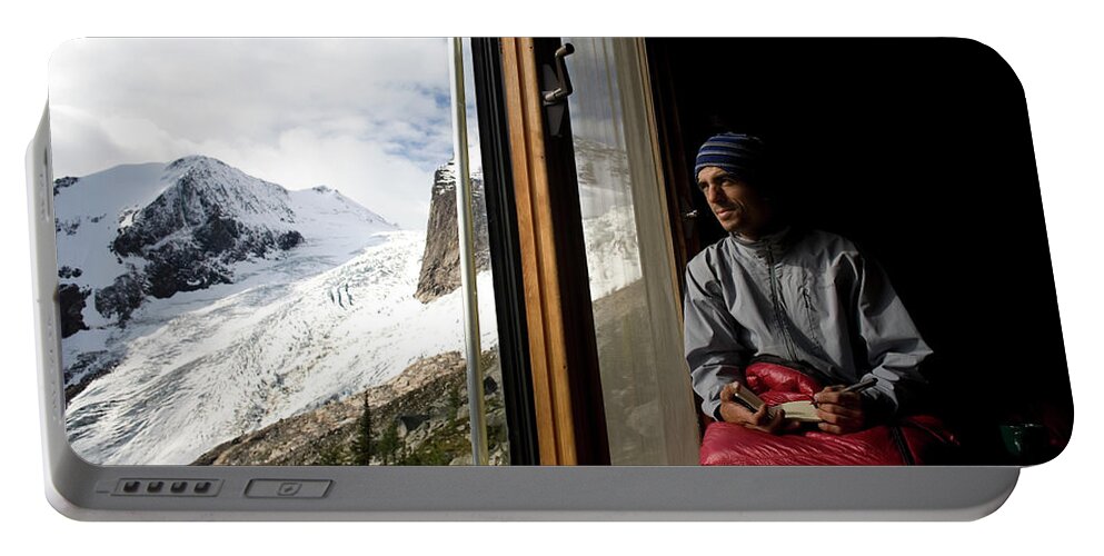 Beanie Portable Battery Charger featuring the photograph A Man Writes In His Journal, While by Aaron Black