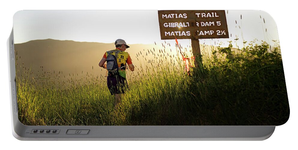 Adult Portable Battery Charger featuring the photograph A Trail Runner Passes A Sign And Trail by Kevin Steele