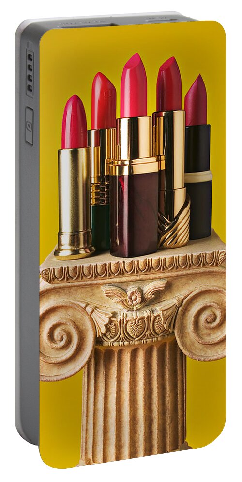 Cosmetics Portable Battery Charger featuring the photograph Five red lipstick tubes on pedestal by Garry Gay