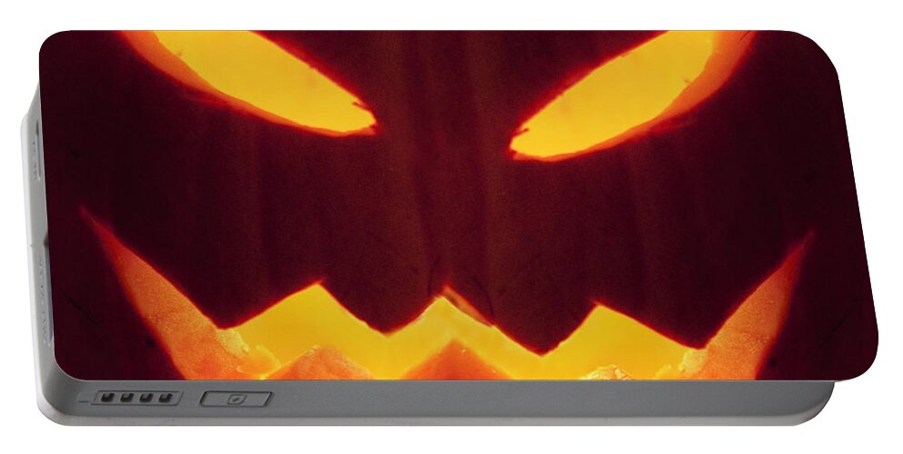 Pumpkin; Glow; Glowing; Dark; Darkness; Jack O Lantern; Horror; Haunting; Haunted; Haunt; Ghoul; Frightening; Moody; Scary; Fright; Eerie; Foreboding; Shadow; Night; Ominous; Evil Fear; Foreboding; Seasonal; Halloween; Carved; Close Up; Eyes; Mouth Portable Battery Charger featuring the photograph Glowing Pumpkin by Margie Hurwich