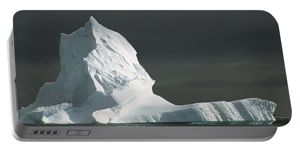 Feb0514 Portable Battery Charger featuring the photograph Grounded Iceberg With Storm Clouds by Colin Monteath