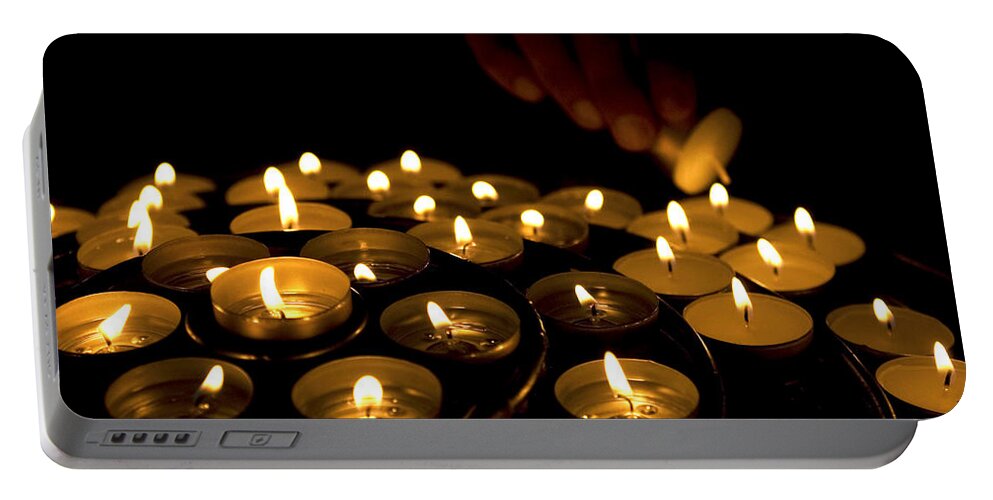 Close Up Portable Battery Charger featuring the photograph Hand lighting candles by Fabrizio Troiani
