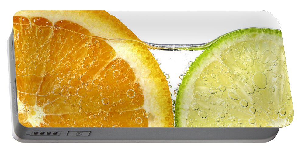 Orange Portable Battery Charger featuring the photograph Orange and lime slices in water by Elena Elisseeva