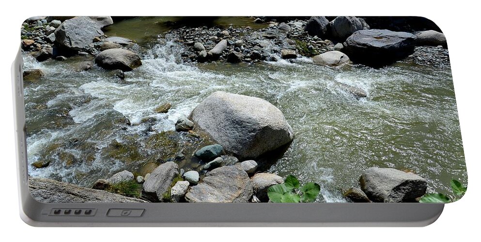 Blue Portable Battery Charger featuring the photograph Stream water foams and rushes past boulders by Imran Ahmed