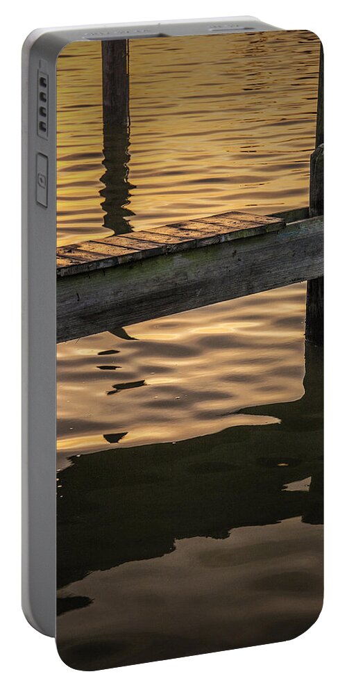 Reflections Portable Battery Charger featuring the photograph Sunrise Reflections on the Water by a Boat Dock by Randall Nyhof