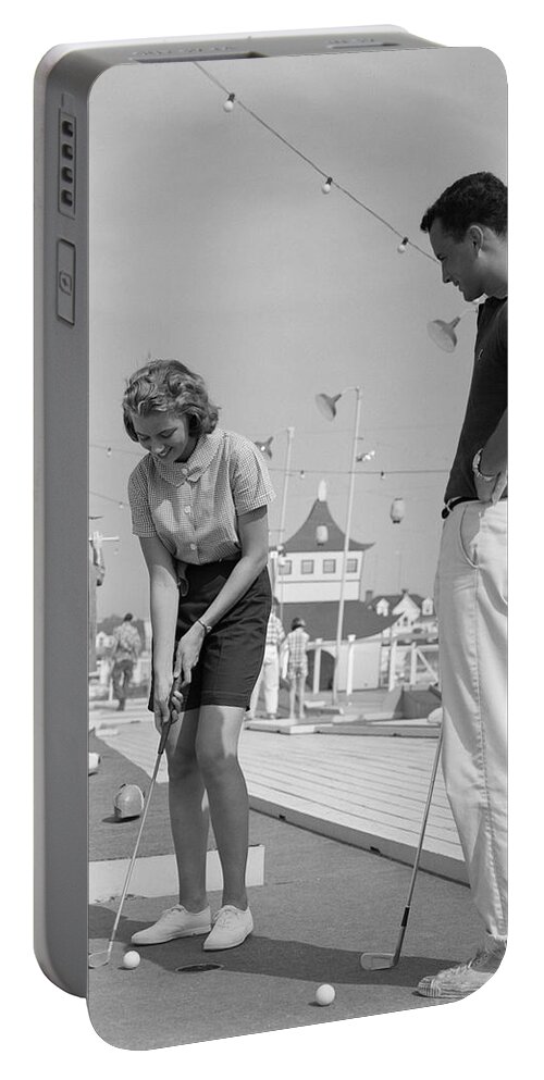 1950s Portable Battery Charger featuring the photograph Teenage Couple Playing Miniature Golf by H Armstrong Roberts and ClassicStock