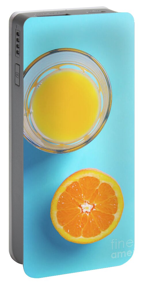 Glass Portable Battery Charger featuring the photograph Glass of orange juice and half of orange #3 by Piotr Marcinski