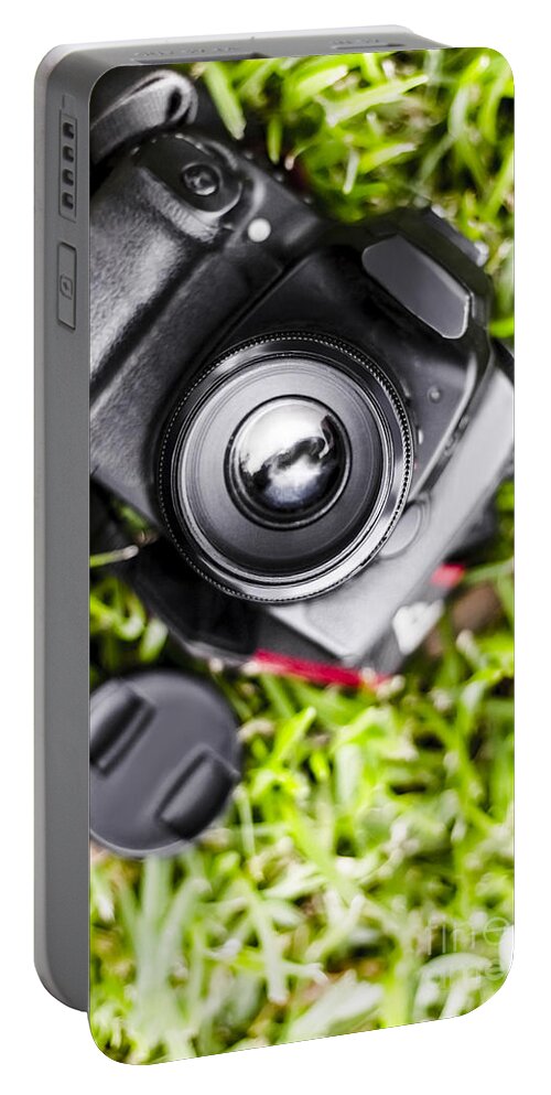 Photography Portable Battery Charger featuring the photograph Digital SLR camera on green grassy field by Jorgo Photography