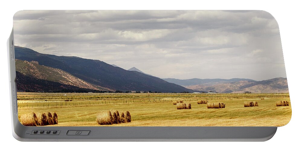 Cloudy Sky Portable Battery Charger featuring the photograph Field of Hay Bales by K Bradley Washburn