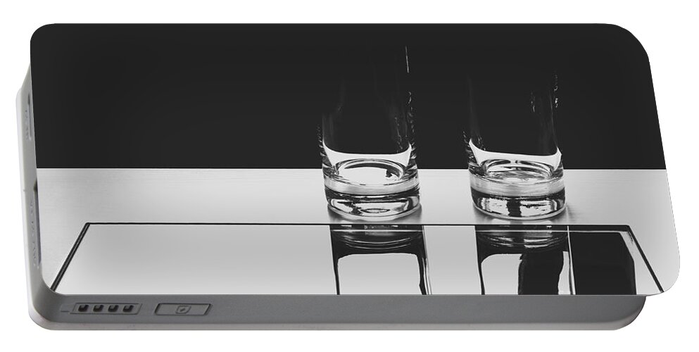 Glasses Portable Battery Charger featuring the photograph Glasses on a table BW by Iryna Liveoak