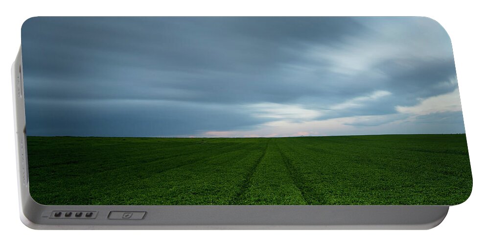 Freedom Portable Battery Charger featuring the photograph Green field and cloudy sky by Michalakis Ppalis