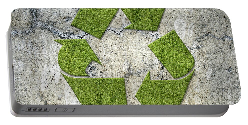 Recycling Portable Battery Charger featuring the photograph Green recycling sign on a concrete wall by GoodMood Art