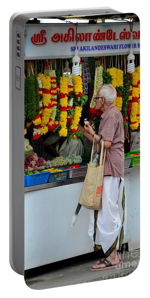 Singapore Portable Battery Charger featuring the photograph Indian man stands at Little India flower garland shop Singapore by Imran Ahmed