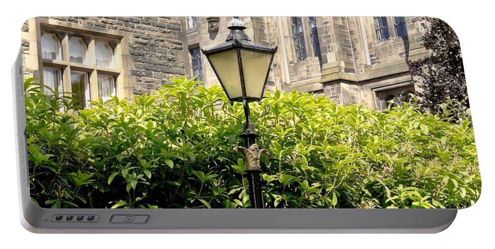 Lamppost Portable Battery Charger featuring the photograph Lamppost in front of green bushes and old walls. by Elena Perelman